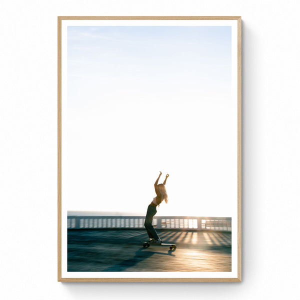 An image of a girl gliding effortlessley and freely on her skateboard, as the sun drops out of the sky behind her. Shot in Ericeira, Portugal.